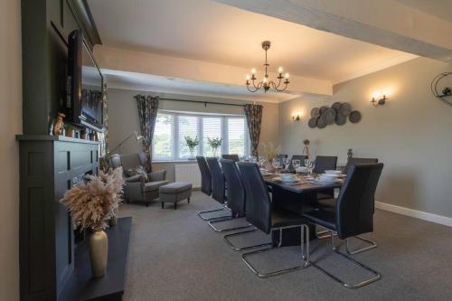 a dining room with a dining table and chairs at The Breckland at Sugar Lane Farm in Bollington