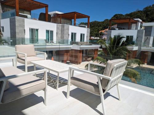 une terrasse avec une table, des chaises et une piscine dans l'établissement Dolphin Villa #09, à West Bay