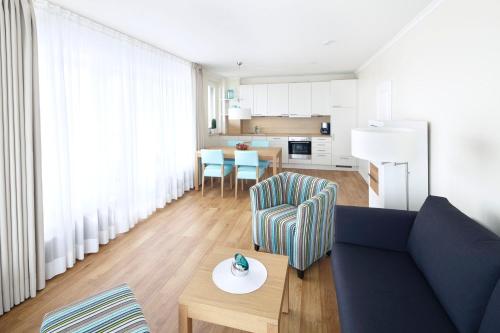 - un salon avec un canapé bleu et une table dans l'établissement Meer & Strand - Haus Meeresstrand Ferienwohnung 202, à Scharbeutz
