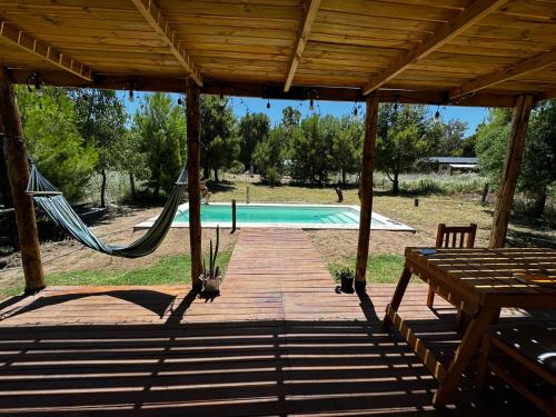 a porch with a hammock and a pool at Casa Monte Hermoso / Sauce grande in Balneario Sauce Grande
