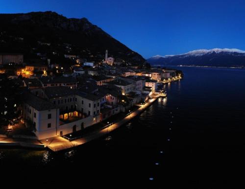 a town on the shore of a body of water at night at Villa Pinetina in Gargnano