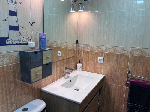 y baño con lavabo, aseo y espejo. en Bahia Suite 1, en Algeciras