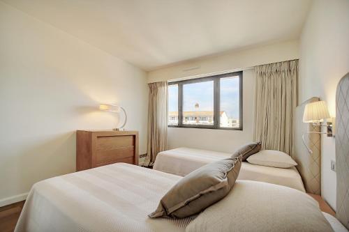 une chambre d'hôtel avec deux lits et une fenêtre dans l'établissement Carlton Riviera Cannes - Dernier étage - Palme d'Or, à Cannes