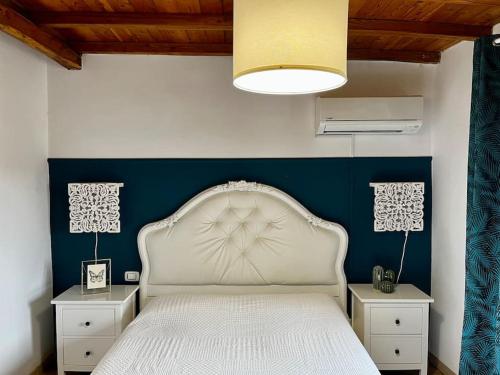 een slaapkamer met een wit bed met een blauwe accentmuur bij Accogliente Trilocale Vista Lago in Anguillara Sabazia