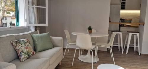 un soggiorno con divano, tavolo e sedie di Machico Heart Suites a Machico