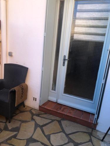 a door to a patio with a window and a chair at F2 port de canet in Canet-en-Roussillon