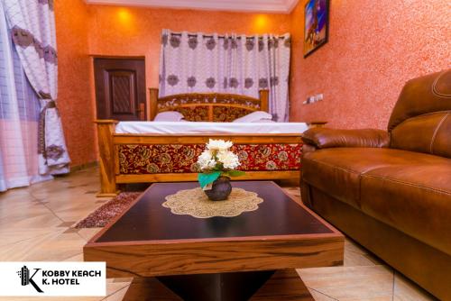 ein Wohnzimmer mit einem Sofa und einem Bett in der Unterkunft Kobby Keach K. Hotel in Kumasi