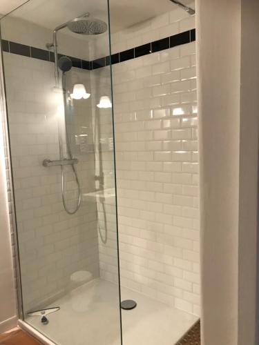 um chuveiro com uma porta de vidro na casa de banho em Chambre d’hôte Lyons la foret em Lyons-la-Forêt