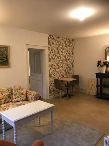 un salon avec un canapé et une table dans l'établissement Chambre La Coccinelle Verte, à Lyons-la-Forêt