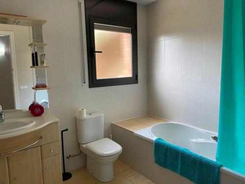 uma casa de banho com uma banheira, um WC e um lavatório. em Habitaciones en Villa Coliving Villa Vistas em San Fausto de Campcentellas