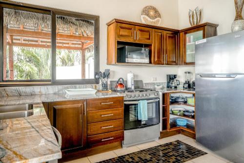 a kitchen with wooden cabinets and a stainless steel refrigerator at Canto Del Mar #13 in Dominical