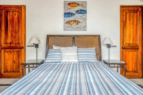 a bedroom with a bed with blue and white stripes at Canto Del Mar #13 in Dominical