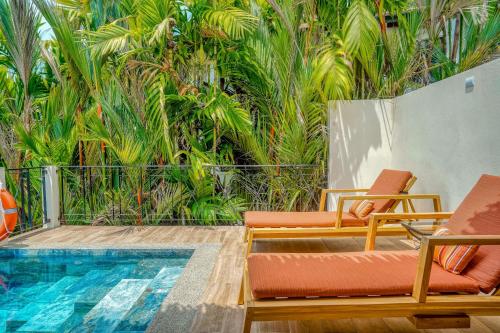 a patio with two chairs and a swimming pool at Canto Del Mar #13 in Dominical