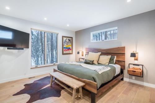 a bedroom with a large bed and a tv at Whitefish Suncrest Charm- Newly Build Modern Townhouse w Pool Table andPet Friendly! in Whitefish