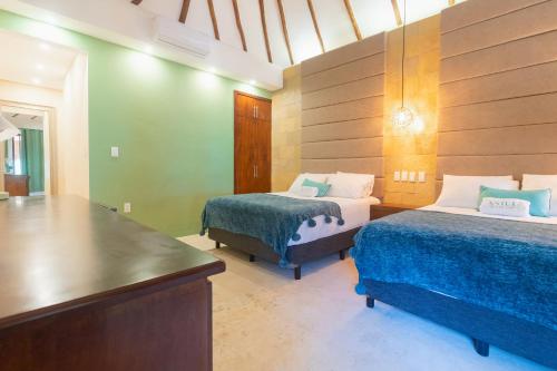a room with two beds and a table in it at Mayan Playa Bacalar in Bacalar