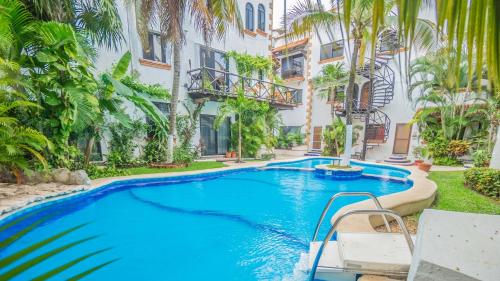 a swimming pool in front of a building at Hacienda San Jose Condo by BVR in Playa del Carmen