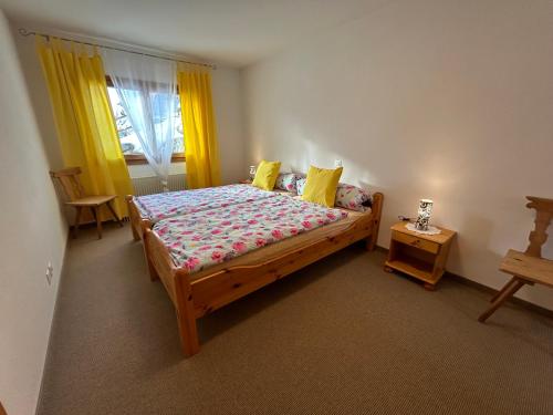- une chambre avec un lit en bois et des rideaux jaunes dans l'établissement Chalet Sonnenschein, à Davos