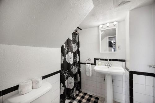 a white bathroom with a sink and a mirror at Charming Studio-Panoramic View-Your Pittsburgh Sanctuary in Pittsburgh