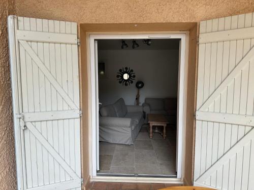 an open door to a living room with a couch at Maison au Pied de la Sainte Victoire in Puyloubier