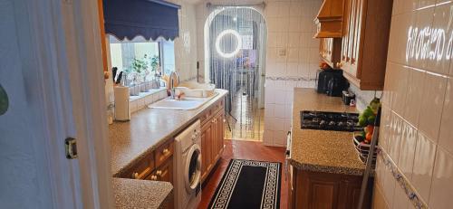 uma grande cozinha com um lavatório e uma janela em Diamond em Abbey Wood