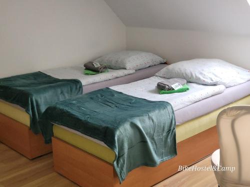 2 łóżka z zielonymi kołdrami w pokoju w obiekcie Bike Hostel&Camp w mieście Przewóz