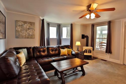 a living room with a brown leather couch and a table at The Bullpen All Star Baseball Rentals in Oneonta