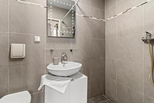 a bathroom with a sink and a toilet and a mirror at Designer Apartments Asaria in Vienna