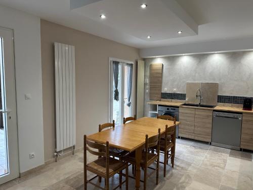 a large kitchen with a wooden table and chairs at Maison au Pied de la Sainte Victoire in Puyloubier