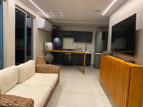 a living room with a couch and a kitchen at Cabaña de Lujo, Isla El Faro in Prado