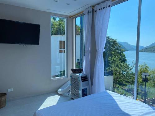 a bedroom with a bed and a large window at Cabaña de Lujo, Isla El Faro in Prado