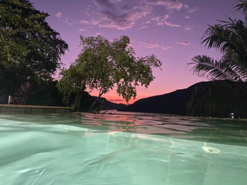 a swimming pool with a sunset in the background at Cabaña de Lujo, Isla El Faro in Prado