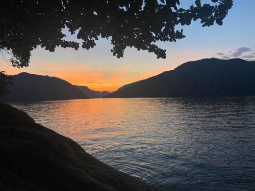a sunset over a body of water with mountains at Cabaña de Lujo, Isla El Faro in Prado
