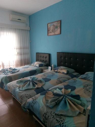 two beds in a room with blue walls at Xaxa Apartments in Ulcinj