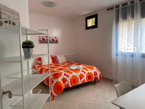 sypialnia z łóżkiem z pomarańczowym kocem w obiekcie Habitaciones en Villa Coliving Villa Vistas w mieście San Fausto de Campcentellas