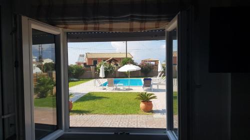 an open window with a view of a pool at Almyra Beach House Corfu in Almiros Beach