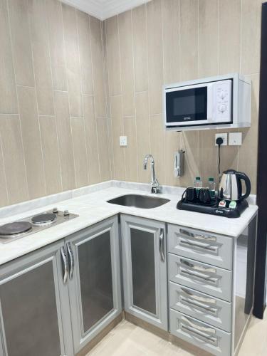 a kitchen with a sink and a microwave at فربيون للشقق الفندقية ابها in Abha