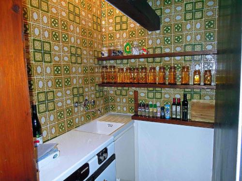 una cocina con encimera con botellas en la pared en Villa Pinetina, en Gargnano
