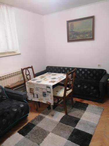 ein Wohnzimmer mit einem Tisch und einem Sofa in der Unterkunft Trojan i Slobodanka in Ribarska Banja