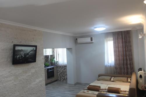 a bedroom with two beds and a television on the wall at Deluxe guest house in Kvariati