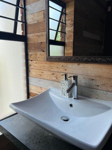 lavabo blanco en el baño con espejo en ALOE cottage Valley of a 1000 hills en Drummond