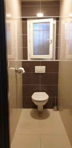 Elle comprend une petite salle de bains pourvue de toilettes et d'une fenêtre. dans l'établissement ARGELES sur MER APPT RDC CADAQUES TOUT CONFORT JARDIN PISCINE PARKING WIFI, à Argelès-sur-Mer