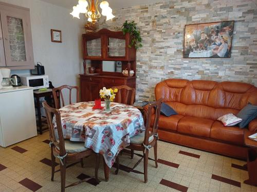 salon ze stołem i kanapą w obiekcie Gîte La Maison de LEA w mieście Saint-Agnant-de-Versillat