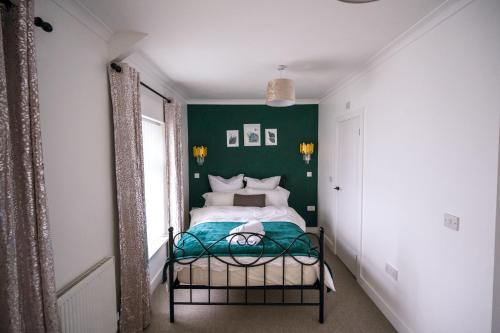 a bedroom with green walls and a bed at Happy Days Afan Forest in Cymmer