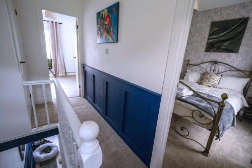 1 dormitorio con 1 cama con pared azul en Happy Days Afan Forest, en Cymmer