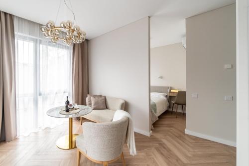 uma sala de estar com uma mesa e uma cama em Golden Apartment Paupys em Vilnius