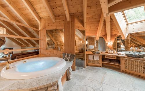 baño grande con bañera grande en el techo de madera en Naturhotel Lüsnerhof, en Luson