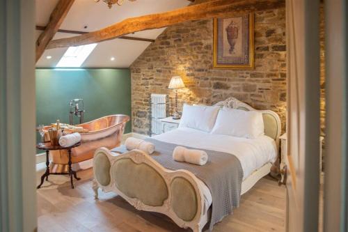 a bedroom with a large bed and a bath tub at The Footmans Cottage in Longwitton