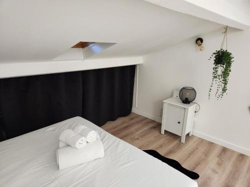 - une chambre avec un lit blanc et un mur noir dans l'établissement Lou Ronsard, à Bouc-Bel-Air