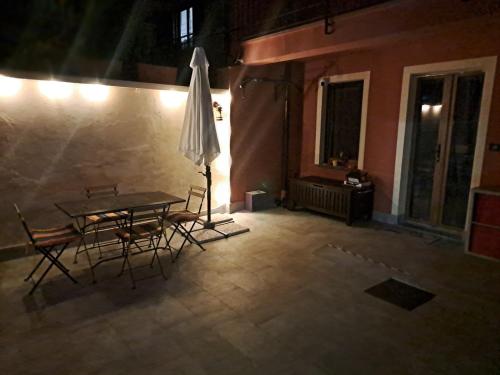 a patio with a table and chairs and an umbrella at B&B Casa V-Ale in Collegno