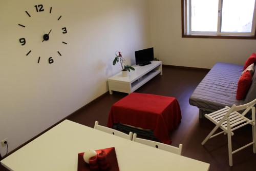 uma sala de estar com um sofá e um relógio na parede em House4U Vila Nova em Vila Nova de Gaia